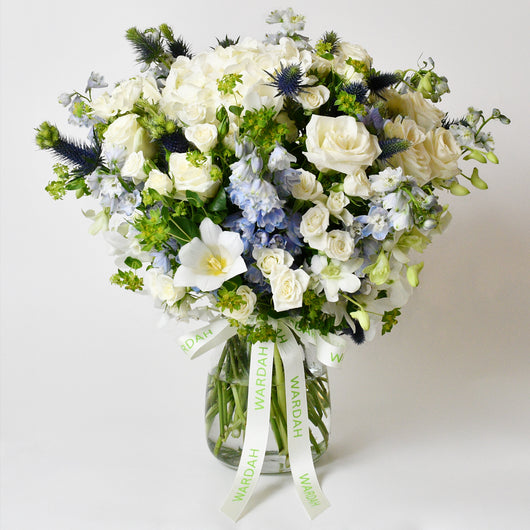 white and blue flower arrangement in a vase