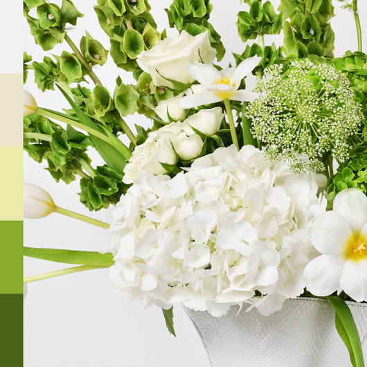 white and green flowers arrangement in white leather vase