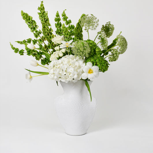 white and green flowers arrangement in white leather vase